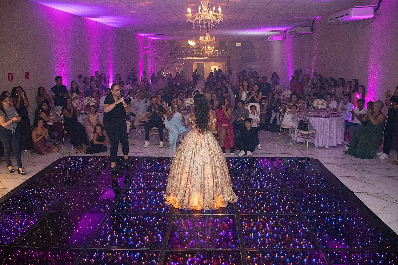 Convidados aplaudindo a debutante na pista